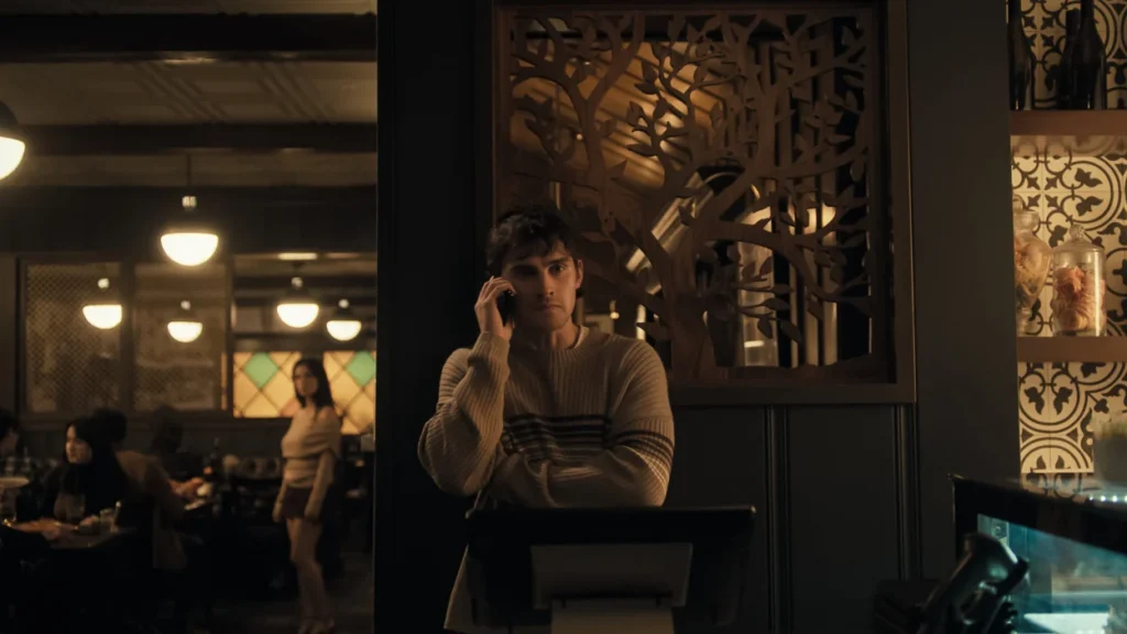 Young man talking on a phone in a dim restaurant