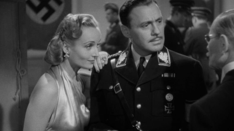 A woman in an evening gown gazes at a man in a Nazi military uniform in this Ernst Lubitsch scene.